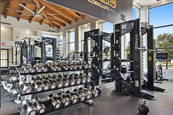 a gym with weights on a rack in front of a window
